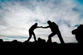 Silhouette of helping hand between two climber Royalty Free Stock Photo